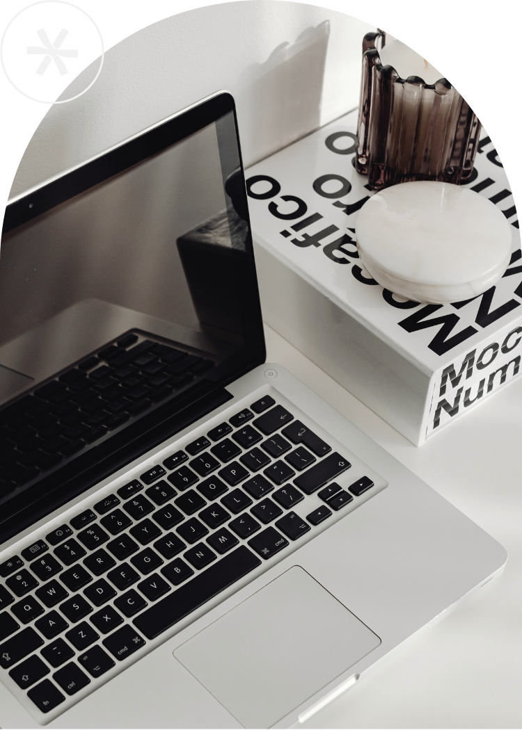 Ordentlich strukturierter Schreibtisch mit Laptop, Notizbuch und digitalen Tools.