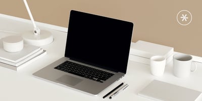 Ordentlich strukturierter Schreibtisch mit Laptop, Notizbuch und digitalen Tools.