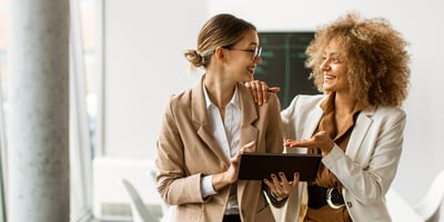 Unternehmerin erklärt ihrer Kundin, auch eine selbstständige Unternehmerin, wie sie am einfachsten in den digitalen Unternehmeralltag einsteigt.